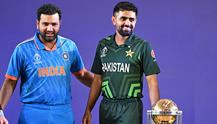 Indias captain Rohit Sharma (L) with Pakistan skipper Babar Azam stand beside the trophy during the Captains Day event at the Narendra Modi Stadium in Ahmedabad, India on October 4, 2023. — AFP