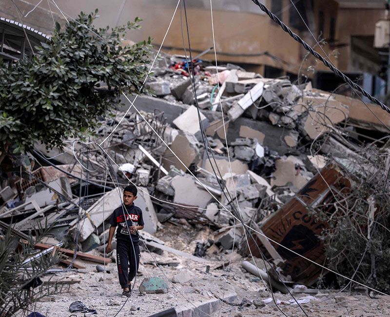 A young boy walks amid the rubble of a building destroyed by Israeli air strikes in Gaza City on October 7, 2023. — AFP