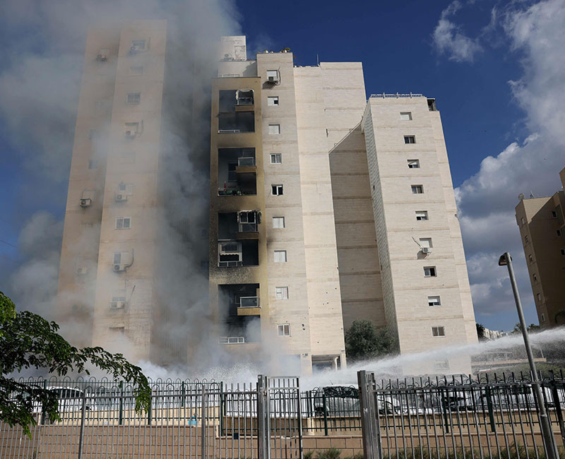 Apartments in a residential building catch fire during a rocket attack from the Gaza Strip in the southern Israeli city of Ashkelon, on October 7, 2023. — AFP