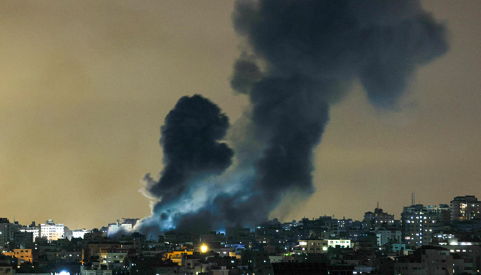 A plume of smoke rises above buildings in Gaza City during an Israeli air strike, on October 8, 2023. — AFP