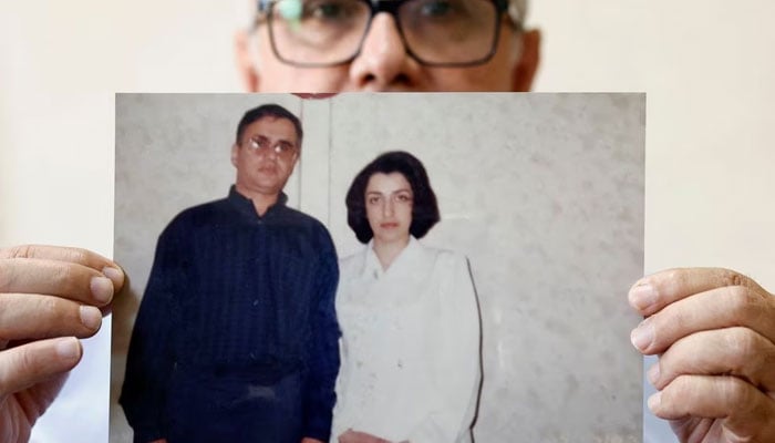 Taghi Ramahi, husband of Narges Mohammadi, a jailed Iranian womens rights advocate, who won the 2023 Nobel Peace Prize, poses with an undated photo of himself and his wife, during an interview at his home in Paris, France, October 6, 2023. — Reuters