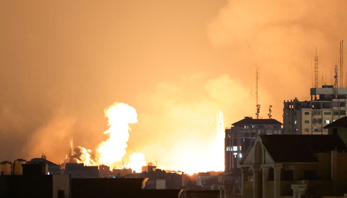 A plume of smoke rises above buildings in Gaza City during an Israeli air strike, on October 8, 2023. — AFP