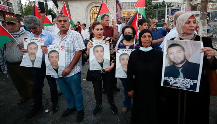 Relatives of Palestinian prisoners in Israeli jails hold their pictures during a demonstration, in Ramallah in the Israeli-occupied West Bank on September 8, 2021.—Reuters