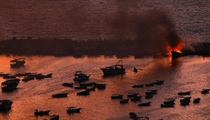 Smoke billows from a boat after a strike by Israel on the port of Gaza City on October 10, 2023. — AFP