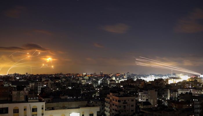 A picture shows rockets fired from Gaza City (R) being intercepted by Israels Iron Dome (L) on October 10, 2023. — AFP