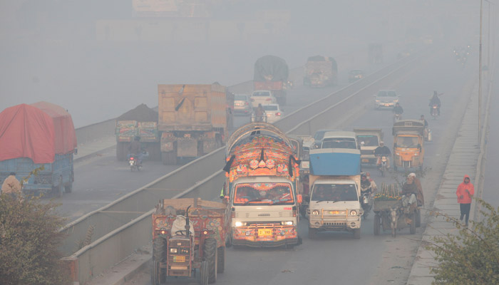 Vehicles move amid dense smog in Lahore, on November 24, 2021. — Reuters