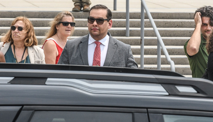 George Santos (R-NY) departs with his lawyer Joseph Murray from the federal courthouse on June 30, 2023 in Central Islip, New York. — AFP