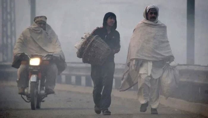 A representational image of men walking on the road on a chilly morning. — Reuters/File
