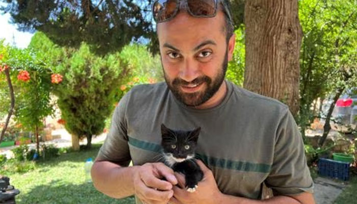 Reuters journalist Issam Abdallah holds a kitten while posing for a picture in Saaideh, Lebanon, July 4, 2023.—Reuters