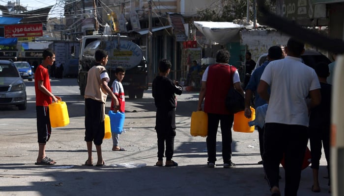 Palestinians queue for water at the Rafah refugee camp, in the southern Gaza Strip on October 15, 2023. — AFP