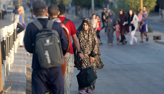 Palestinian families flee their homes following an Israeli attack on the Rafah refugee camp, in the southern Gaza Strip on October 15, 2023. — AFP