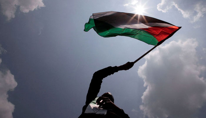 A person waves a Palestinian flag during a solidarity gathering in support of Palestinians in Kuala Lumpur, Malaysia. — Reuters/File