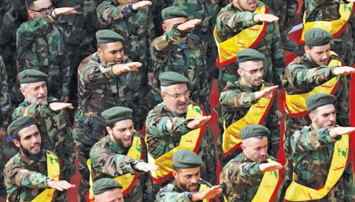 MEMBERS of Hezbollah salute during the funeral of three fighters killed in combat in Syria in the southern Lebanese city of Nabatieh on Nov 8. — AFP