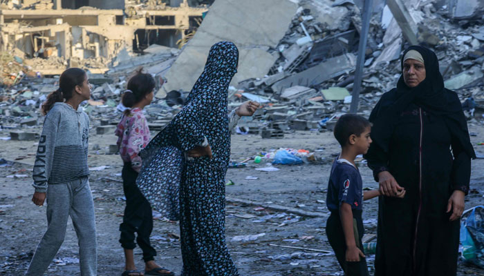 Palestinians walks amid the rubble of buildings destroyed in an Israeli airstrike in the Rafah refugee camp in the southern of Gaza Strip, on October 16, 2023. — AFP