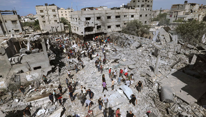 An overview of destroyed buildings as people gather to search for victims following an Israeli airstrike at the Rafah, in the southern Gaza Strip on October 17, 2023. — AFP