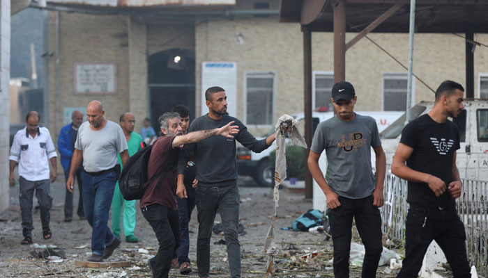 People inspect the area of Al-Ahli hospital, where hundreds of Palestinians were martyred in an Israeli attack in Gaza City, October 18, 2023. — Reuters