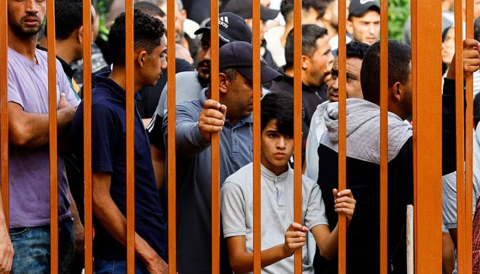 People watch through the rails of the gate of a hospital where the bodies of Palestinians killed in the Israeli strikes are kept, in Khan Younis, southern Gaza Strip October 10, 2023. — Reuters