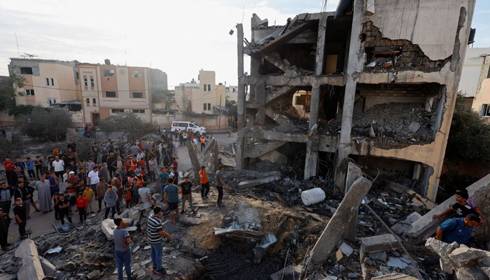 Palestinians search for casualties under the rubble of a building destroyed by Israeli strikes in Khan Younis in the southern Gaza Strip, October 17. — Reuters