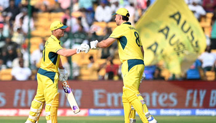 Australia´s David Warner (left) and Mitchell Marsh bump their fists during the 2023 ICC Men´s Cricket World Cup  match between Australia and Pakistan at the M. Chinnaswamy Stadium in Bengaluru on October 20, 2023. — AFP