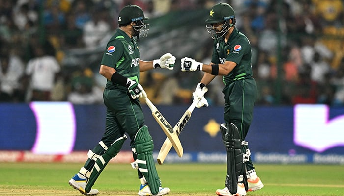 Pakistans Imam-ul-Haq (L) is congratulated by his teammate Abdullah Shafique after scoring a half-century (50 runs) during the 2023 ICC Mens Cricket World Cup one-day international (ODI) match between Australia and Pakistan at the M. Chinnaswamy Stadium in Bengaluru on October 20, 2023. — AFP