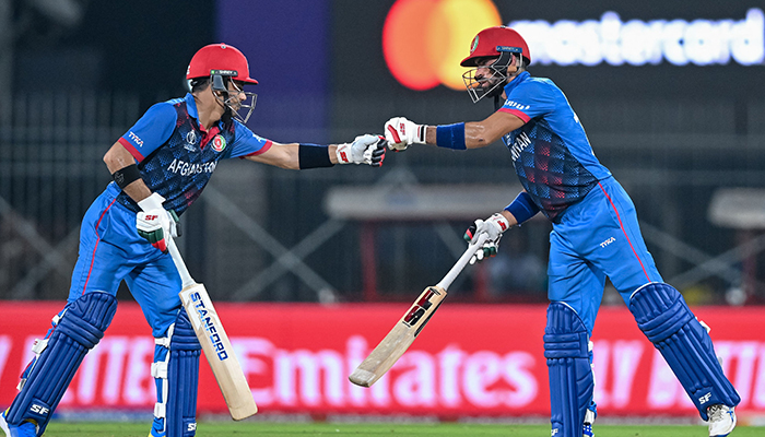 Afghanistan´s Ibrahim Zadran and Rahmanullah Gurbaz (L) bump their fists during the 2023 ICC Men´s Cricket World Cup one-day international (ODI) match between Pakistan and Afghanistan at the MA Chidambaram Stadium in Chennai on October 23, 2023. — AFP