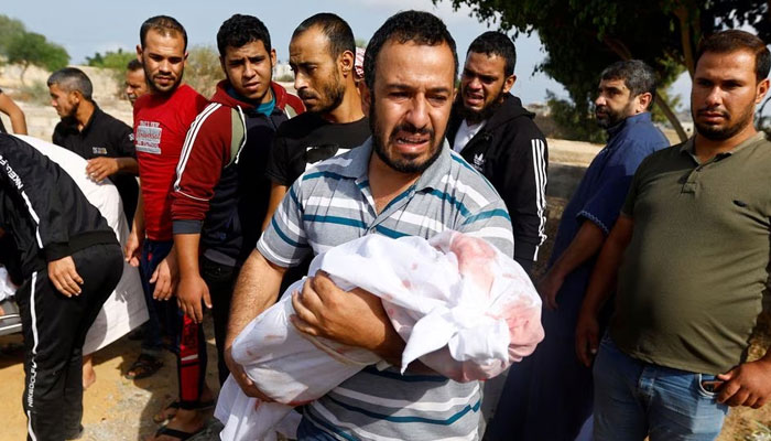 A mourner carries the body of a child, during the funeral of Palestinians from al-Astal family, who were killed in Israeli strikes, in Khan Younis in the southern Gaza Strip. —Reuters