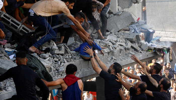 Palestinians carry a child casualty at the site of an Israeli strike on a house, in Khan Younis, in the southern Gaza Strip, October 24, 2023. — Reuters