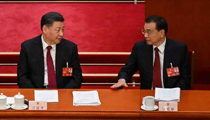 Chinas President Xi Jinping (L) speaks with Premier Li Keqiang (R) during the opening session of the National People´s Congress (NPC) at the Great Hall of the People in Beijing on March 5, 2023. Former Chinese premier Li Keqiang has died after suffering a heart attack, state media reported on October 27, 2023. —AFP