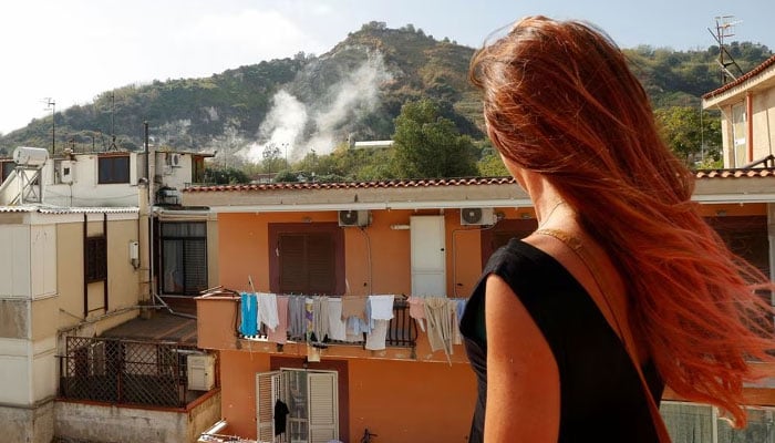 Stefania Briganti, a ballerina in Milan looks at the sulphuric fumes billowing from the Campi Flegrei (Phlegraean Fields) volcanic region in Pozzuoli, as she plans to move to Pozzuoli to be with her boyfriend despite repeated earthquakes in the area, Italy, October 10, 2023.—Reuters