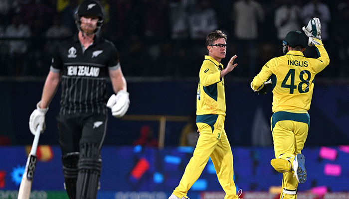 Australias Adam Zampa (centre) celebrates with teammate Josh Inglis after taking the wicket of New Zealands Mitchell Santner (left) during the World Cup ODI match between Australia and New Zealand at the Himachal Pradesh Cricket Association Stadium in Dharamsala on October 28, 2023. — AFP