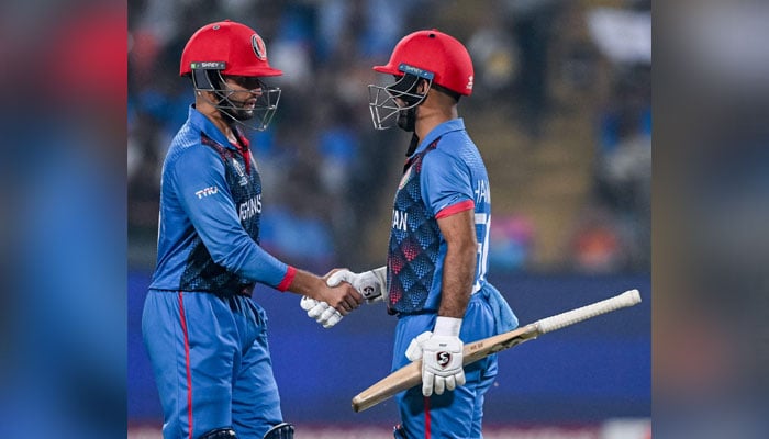 Afghanistan’s captain Hashmatullah Shahidi celebrates with teammate Azmatullah Omarzai (L) after scoring a half-century (50 runs) during the 2023 ICC Men’s Cricket World Cup one-day international (ODI) match between Afghanistan and Sri Lanka at the Maharashtra Cricket Association Stadium in Pune on October 30, 2023. — AFP