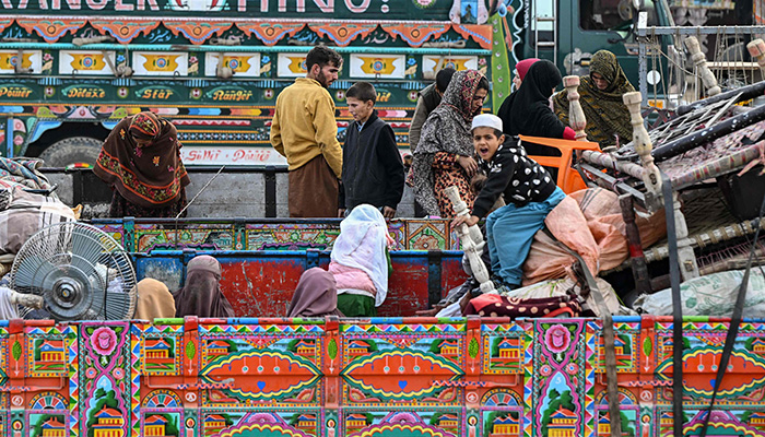 Afghan refugees arrive in a truck at a holding centre as they prepare to depart for Afghanistan, in Landi Kotal on November 1, 2023. — AFP