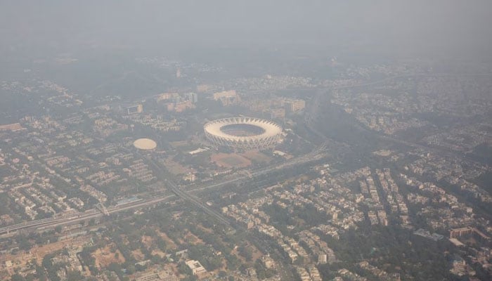 An aerial view shows residential buildings and a stadium shrouded in smog in New Delhi, India, October 27, 2023. — Reuters