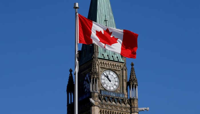 A Canadian flag flies in front of the Peace Tower on Parliament Hill in Ottawa, Ontario, Canada, March 22, 2017. — Reuters