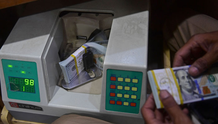 $100 bills being counted in machine in this undated picture. — AFP/File