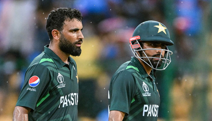 Pakistan’s Fakhar Zaman and his captain Babar Azam (R) leaves the field as rain stops play during the 2023 ICC Men´s Cricket World Cup one-day international (ODI) match between New Zealand and Pakistan at the M. Chinnaswamy Stadium in Bengaluru on November 4, 2023. — AFP