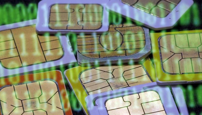 SIM cards are reflected on a monitor showing binary digits in this photo illustration. — Reuters/File