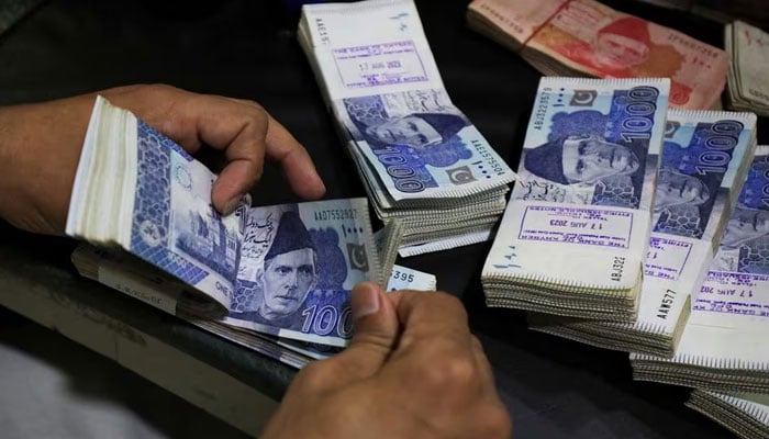 An employee counts Pakistani rupee notes at a bank in Peshawar, Pakistan August 22, 2023. — Reuters