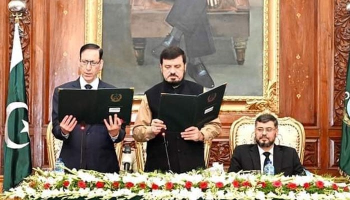 Justice (retd) Arshad Hussain Shah (left) takes oath as Khyber Pakhtunkhwas interim chief minister on November 12, 2023. — X/@IsfPeshawar4