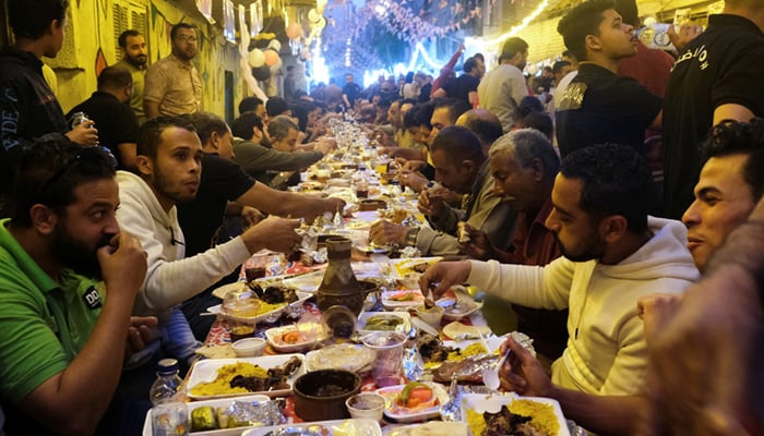Residents of Ezbet Hamada partake in an iftar meal, Mataria, Cairo, Egypt, April 16, 2022. — Reuters