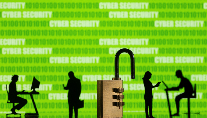 3D printed models of people working on computers and padlocks are seen in front of displayed cyber security words and binary code in this picture illustration taken, on February 1, 2022. — Reuters