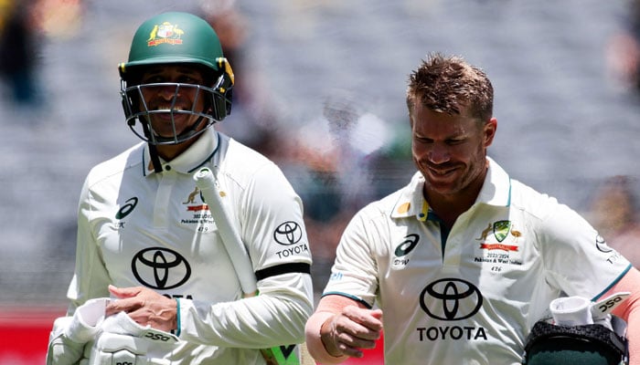 Australias Usman Khawaja (left) and David Warner leave at the lunch break during the first day of the first Test cricket match between Australia and Pakistan at Optus Stadium in Perth on December 14, 2023. — AFP