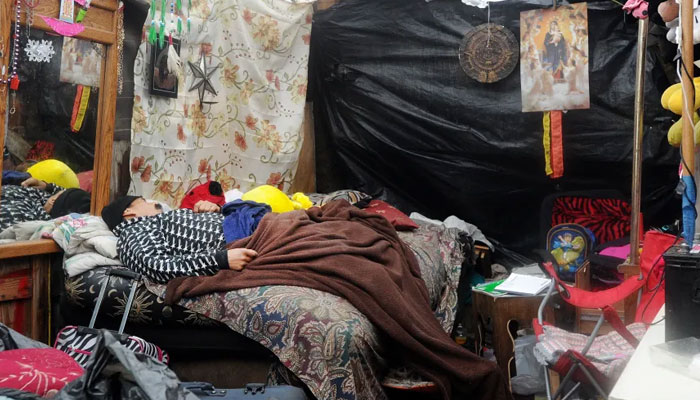 A man sleeps at a Silicon Valley homeless encampment known as The Jungle in San Jose.