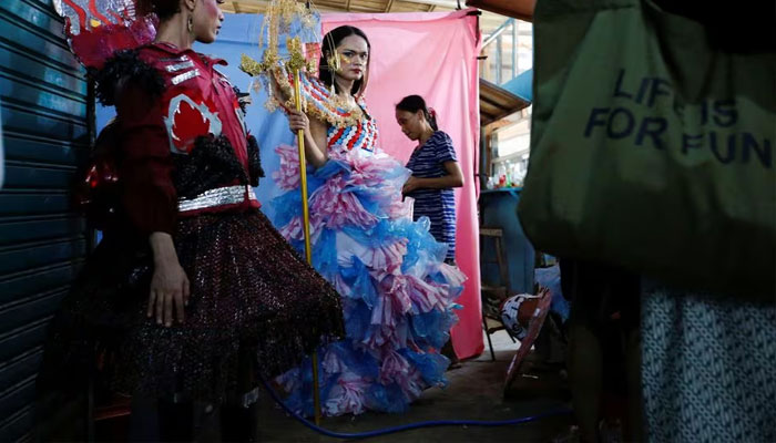 Trans women wearing recycled material dresses to bring awareness to LGBT rights and environmental protection stand before a Trans Super Heroes fashion show at a traditional market in Jakarta, Indonesia, December 17, 2023. —Reuters