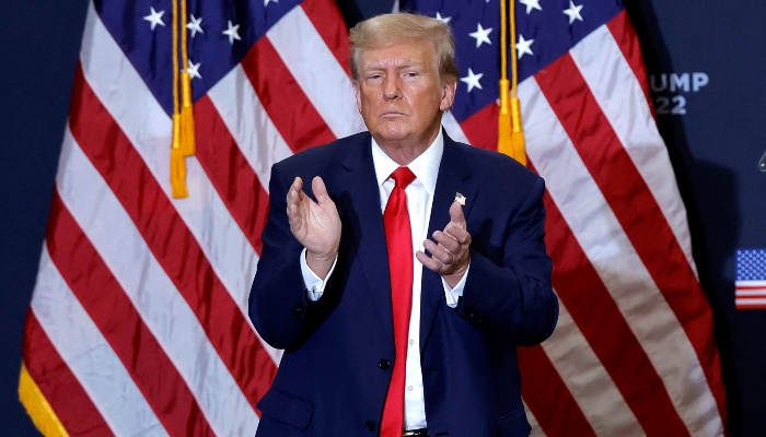 Former US President Donald Trump applauds at the end of a campaign event in Waterloo, Iowa, on December 19, 2023. —AFP