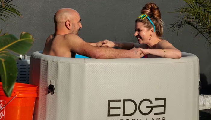 Michael Brougham and Sarah Mitchell, both from Los Angeles, hold hands after entering an ice bath for 3 minutes of speed dating, as people plunge into baths of freezing cold water to help break the ice, in Santa Monica, California, US, December 16, 2023. —Reuters