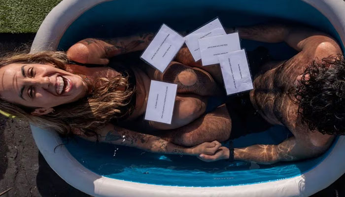 Marcela Bossia of Brazil laughs in an ice bath with Aryan Vavani of New York, as people plunge into baths of freezing cold water to help break the ice while speed dating, in Santa Monica, California, US, December 16, 2023. —Reuters