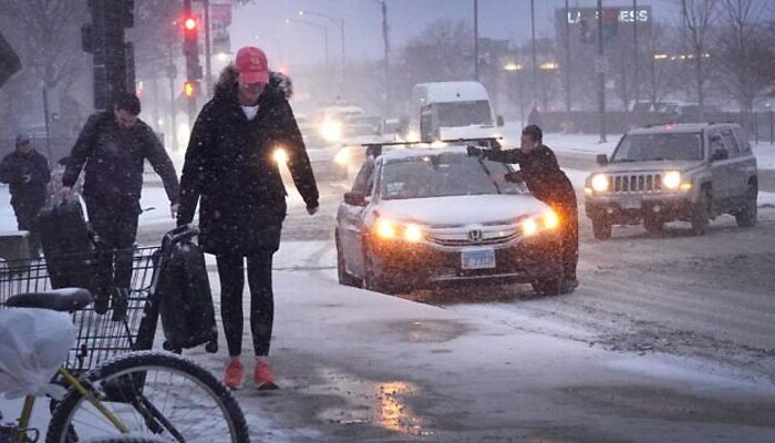 Pedestrians navigate a snow-covered sidewalk as temperatures hang in the single-digits on December 22, 2022 in Chicago, Illinois. — AFP/File