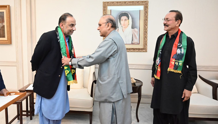 PPP co-Chairman Asif Ali Zardari (centre) presents partys souvenir to Raza Haroon (left) and Anees Advocate (right) after the two former MQM leaders joined PPP. — PPP