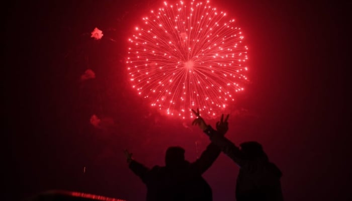 A man watches the fireworks display during the New Year celebrations in Karachi. —AFP